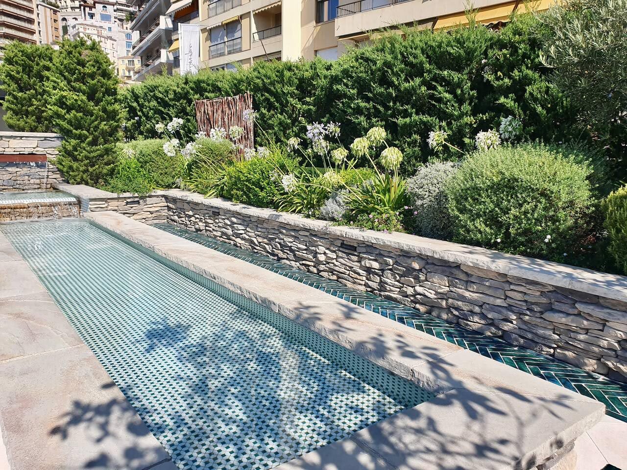 Pièce d'eau linéaire habillée de mosaïque verte, entourée d'un mur en pierre sèche, Monaco